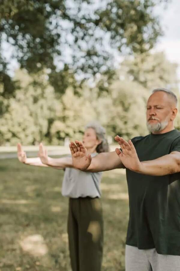 Adultos mayores haciendo ejercicios de estiramiento al aire libre